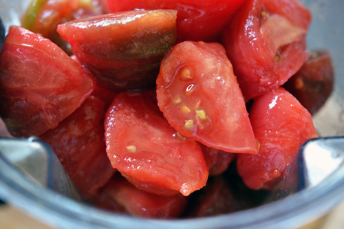 Adding the tomatoes into the blender.