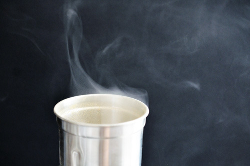 A spice grinder with smoke coming out of the top.