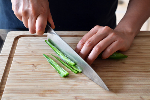 Someone thinly slicing the jalapeño skin for spicy pineapple salsa.