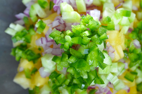 The ingredients for spicy pineapple salsa in a large bowl.